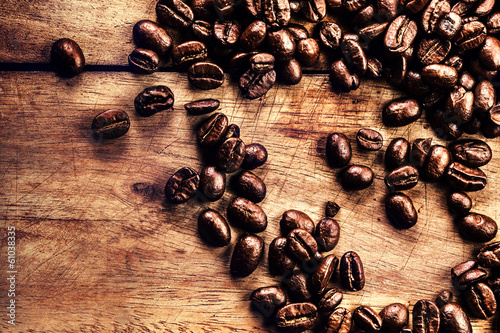 Coffee on grunge wooden background closeup. Roasted coffee bean