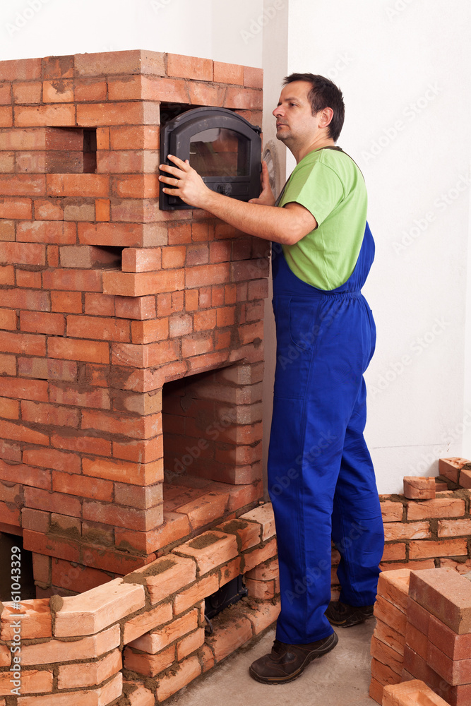 Worker building a masonry heater Worker building a masonry heater
