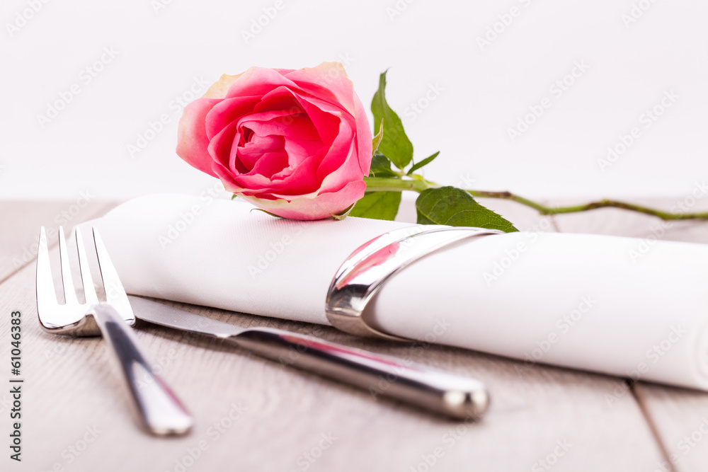 romantisch gedeckter tisch mit silberbesteck und einer rose