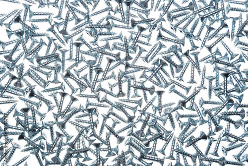 Pile of many chipboard screws on white background