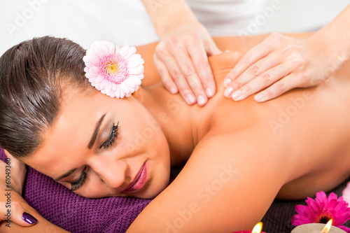 junge frau entspannt bei einer rücken massage im salon