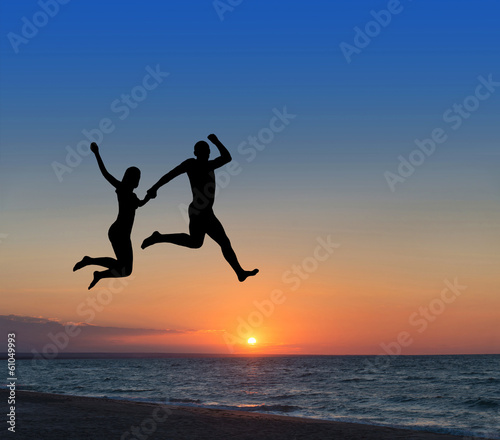 loving couple jumping highly in the sky at beach resort