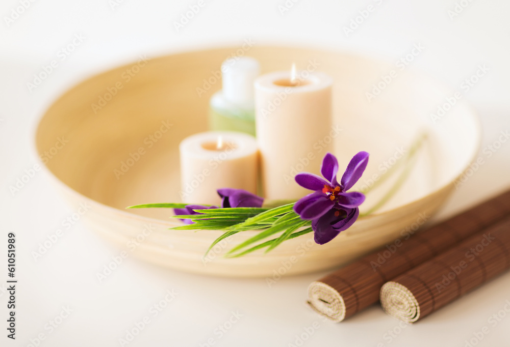 candles and iris flowers in wooden bowel and mat