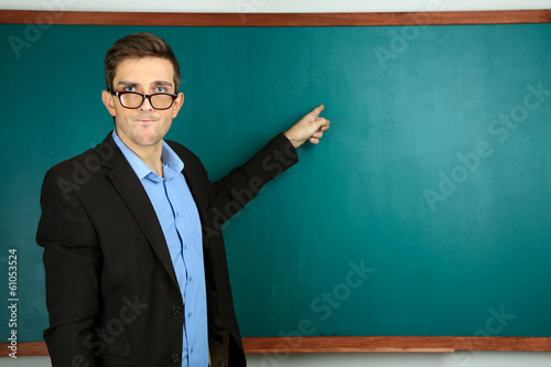 Young teacher near chalkboa...
