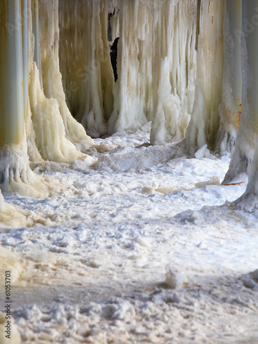 Winter scenery. Baltic Sea. Ice formations icicles on pier poles #61053703