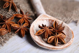 Star anise in wooden spoon, on wooden background