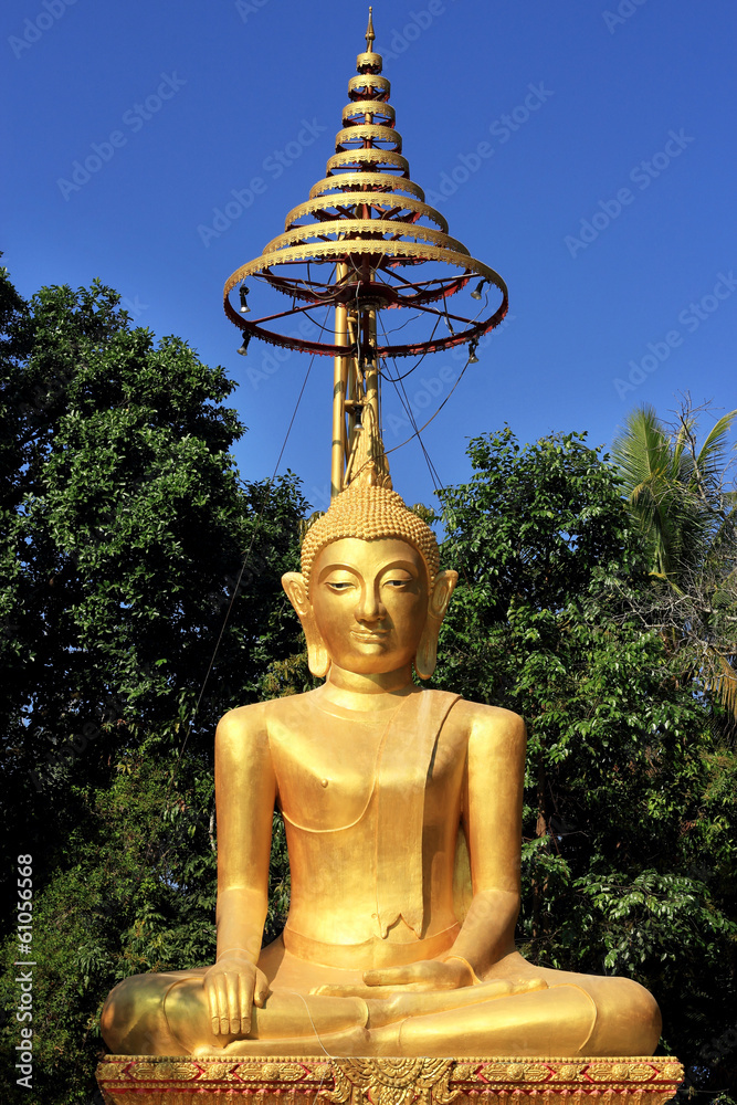 Obraz premium Buddha statue under golden umbrella
