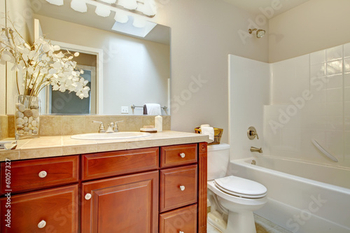 Beautiful  bright bathroom with cherry wood cabinets