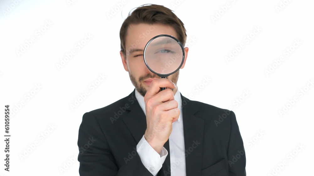 Businessman looking through a magnifying glass Businessman looking through a magnifying glass