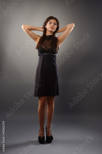 Full length portrait of an elegant woman in black mini dress