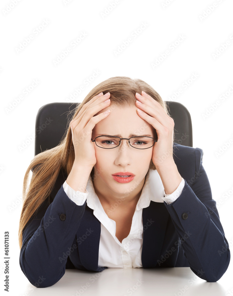 Worried, sad business woman sitting by the table. Worried, sad business woman sitting by the table.