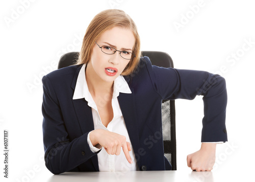 Fotografi Attractive business woman by the table, bossy behaviour.