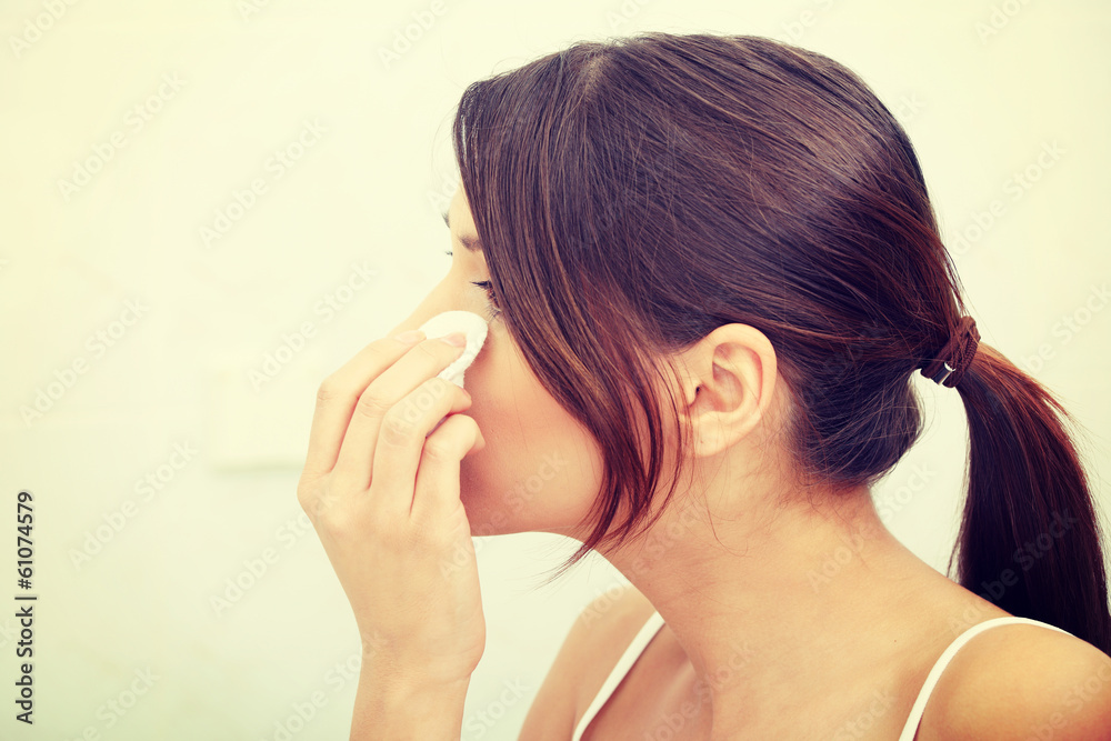 Young beautiful caucasian woman cleaning her face Young beautiful caucasian woman cleaning her face