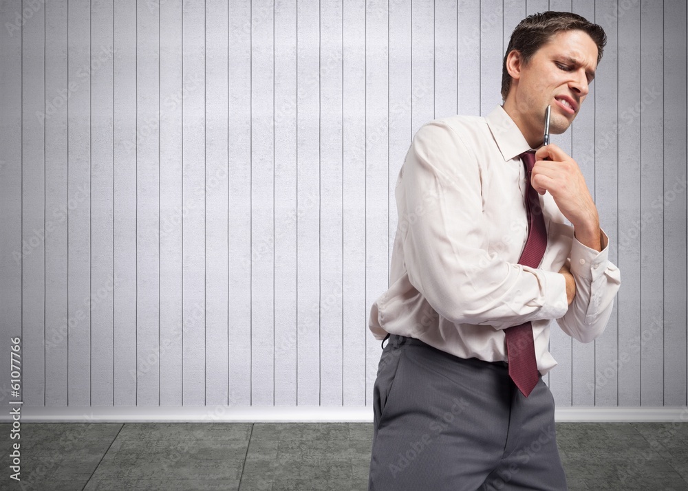 Composite image of thoughtful businessman holding pen to chin Composite image of thoughtful businessman holding pen to chin