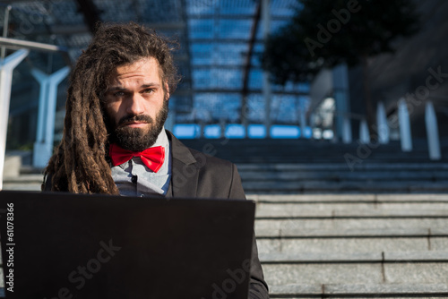 Stylish elegant dreadlocks businessman using notebook