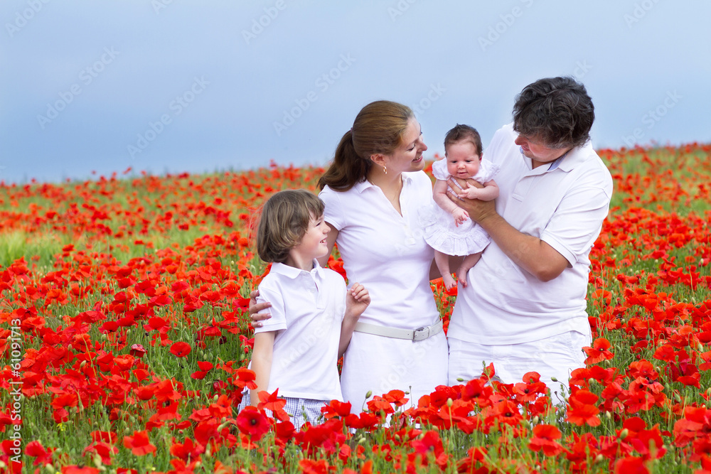 Beautiful young family with a son and newborn daughter in a red Beautiful young family with a son and newborn daughter in a red
