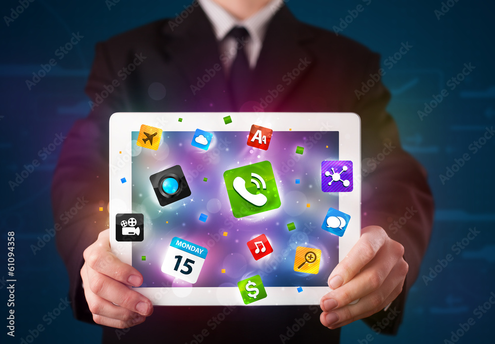 Businessman holding a tablet with modern colorful apps and icons Businessman holding a tablet with modern colorful apps and icons