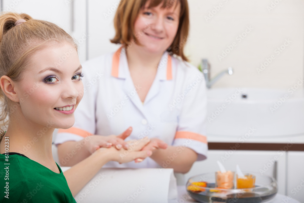 Beautician applying moisturizing cream on client hands Beautician applying moisturizing cream on client hands