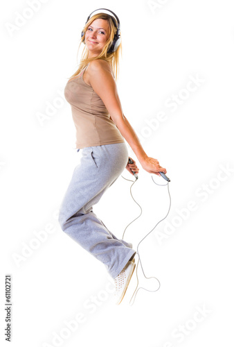 Sport girl with headphoes doing exercise with skip jump rope photo