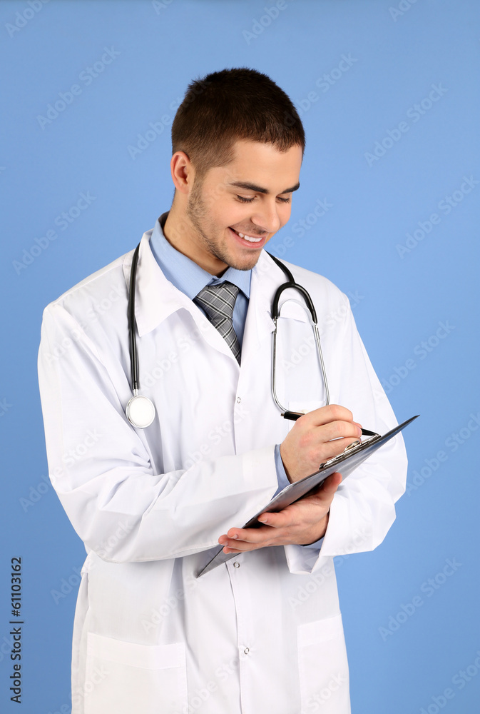 Male Doctor standing with folder, on blue background Male Doctor standing with folder, on blue background