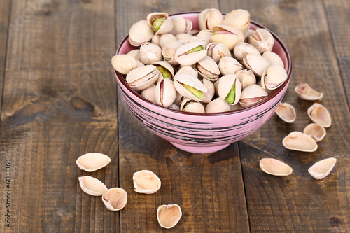 Tableau sur toile Pistachio nuts in bowl on wooden background