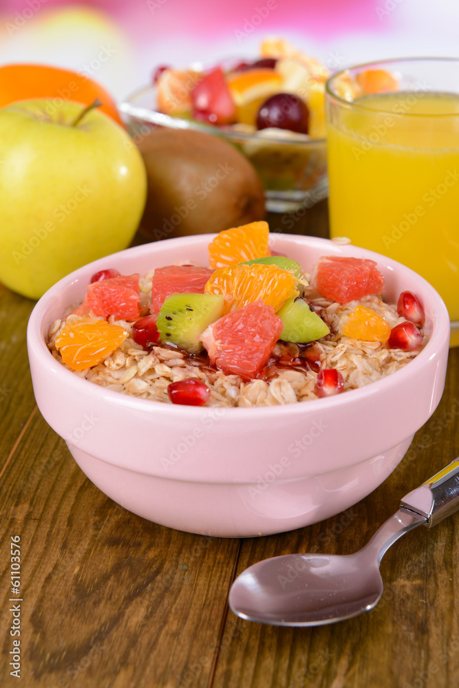 Delicious oatmeal with fruit in bowl on table close-up