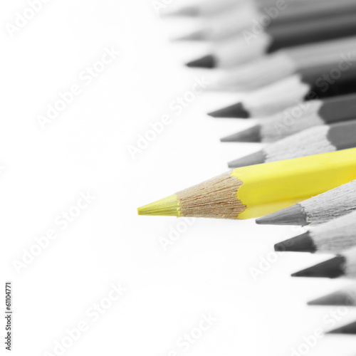 One yellow pencil standing out from gray pencils