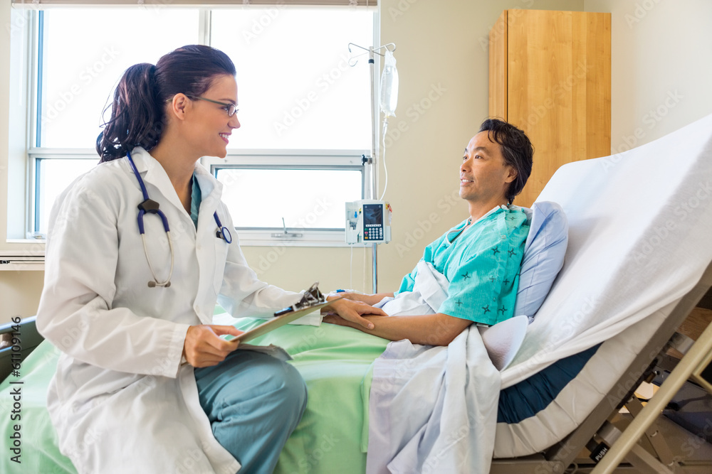 Obraz premium Doctor Consoling Male Patient Relaxing On Hospital Bed