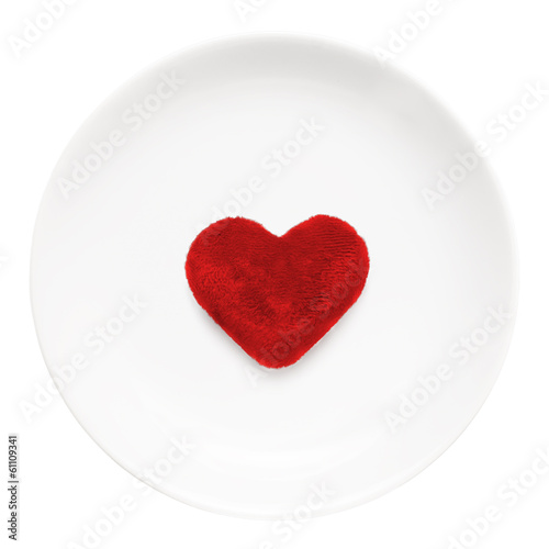 Red heart on a plate close-up isolated on a white background