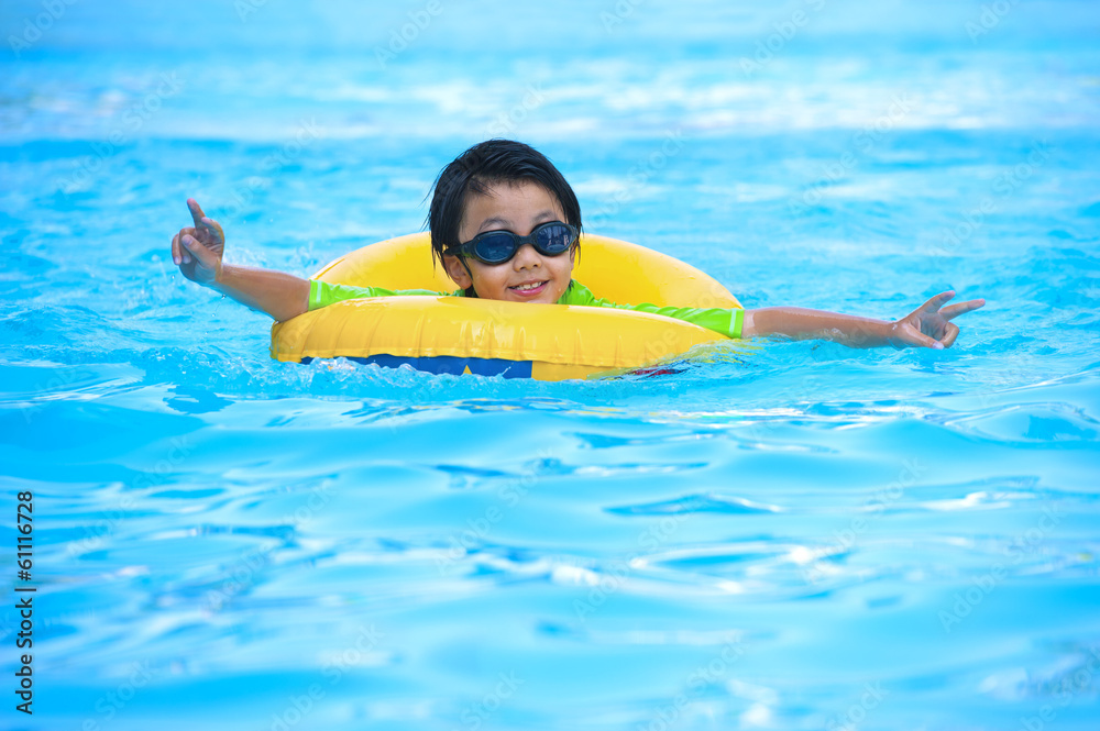 Asian boy in tube learning to swim