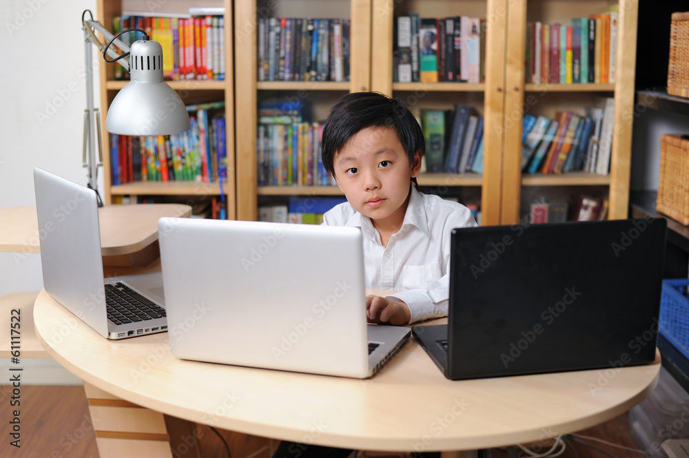 Intelligent school child working on multiple laptop computers Intelligent school child working on multiple laptop computers