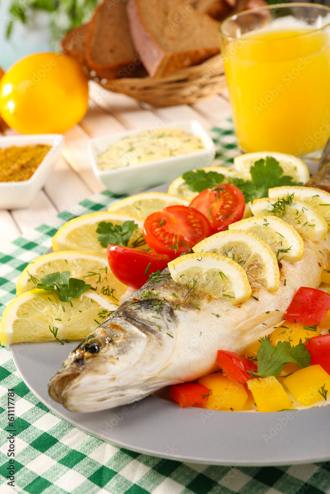 Delicious grilled fish on plate on table close-up Delicious grilled fish on plate on table close-up