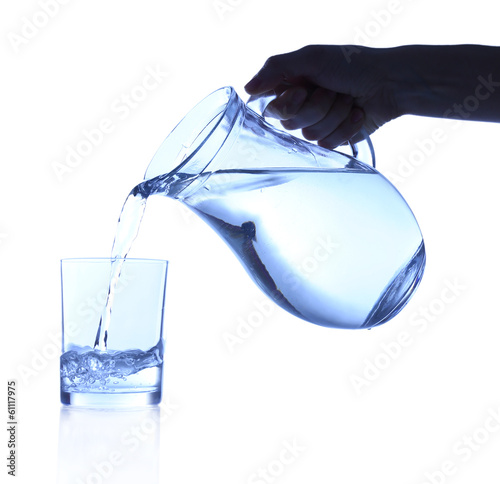 Pouring water into glass on blue background