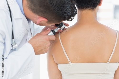 Obraz na plátně Dermatologist examining mole on back of woman