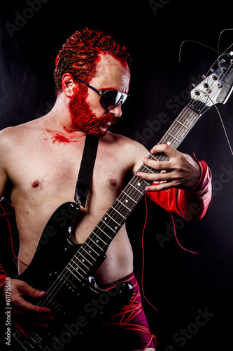 guitarist with electric guitar black  wearing face paint and red