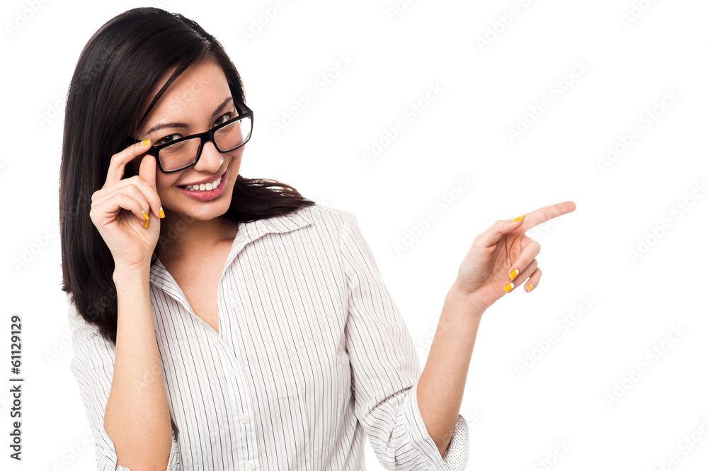 Woman adjusting her spectacles and pointing away Woman adjusting her spectacles and pointing away