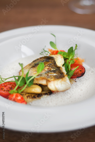 Close image of fish on dish with shrimps in restaurant