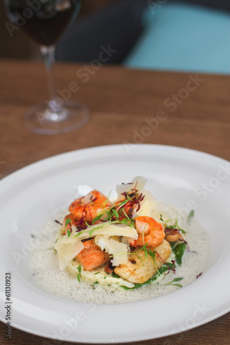 Image of tasty salad with shrimps and cheese in restaurant