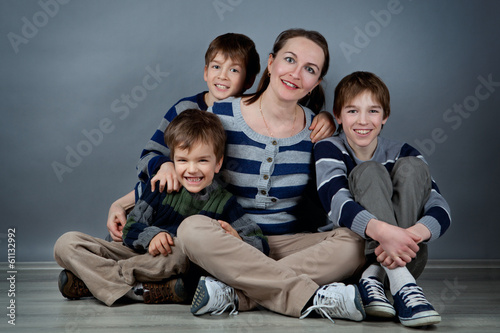 Portrait of happy mother and three sons, studio