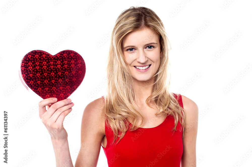 Smiling teen girl showing heart shape gift to camera Smiling teen girl showing heart shape gift to camera