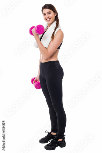 Young girl lifting dumbbells, biceps exercise