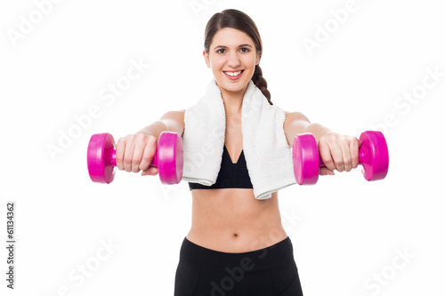 Trainer holding dumbbells in her outstretched arms