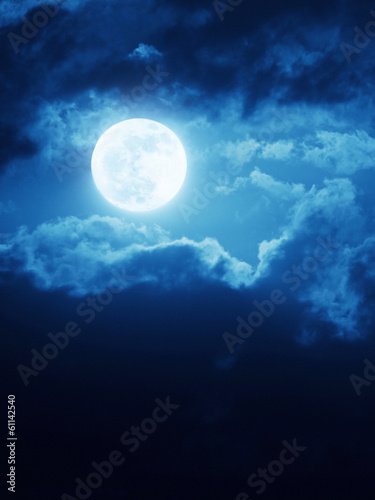 Dramatic Moonrise With Deep Blue Nightime Sky and Clouds