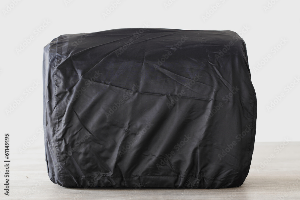 Shoulder canvas camera with rain cover on wooden table Shoulder canvas camera with rain cover on wooden table