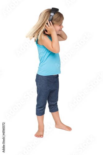 Cute little girl listening to music and dancing