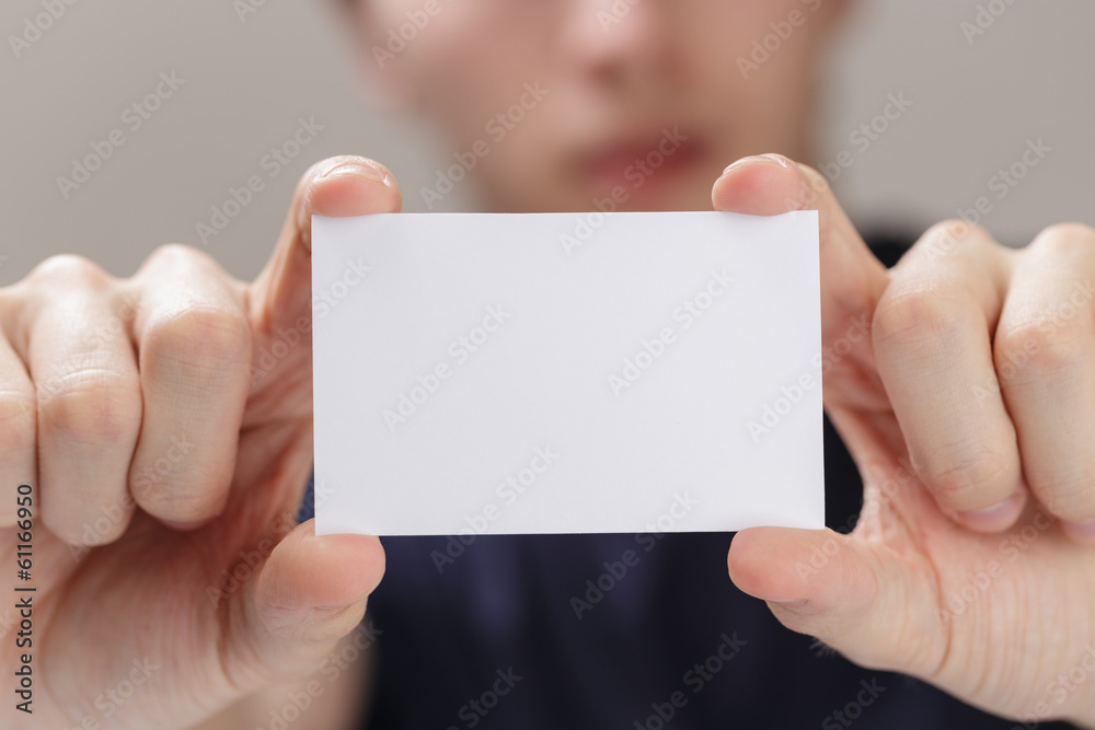 adult man hand holding empty business card in front of camera adult man hand holding empty business card in front of camera