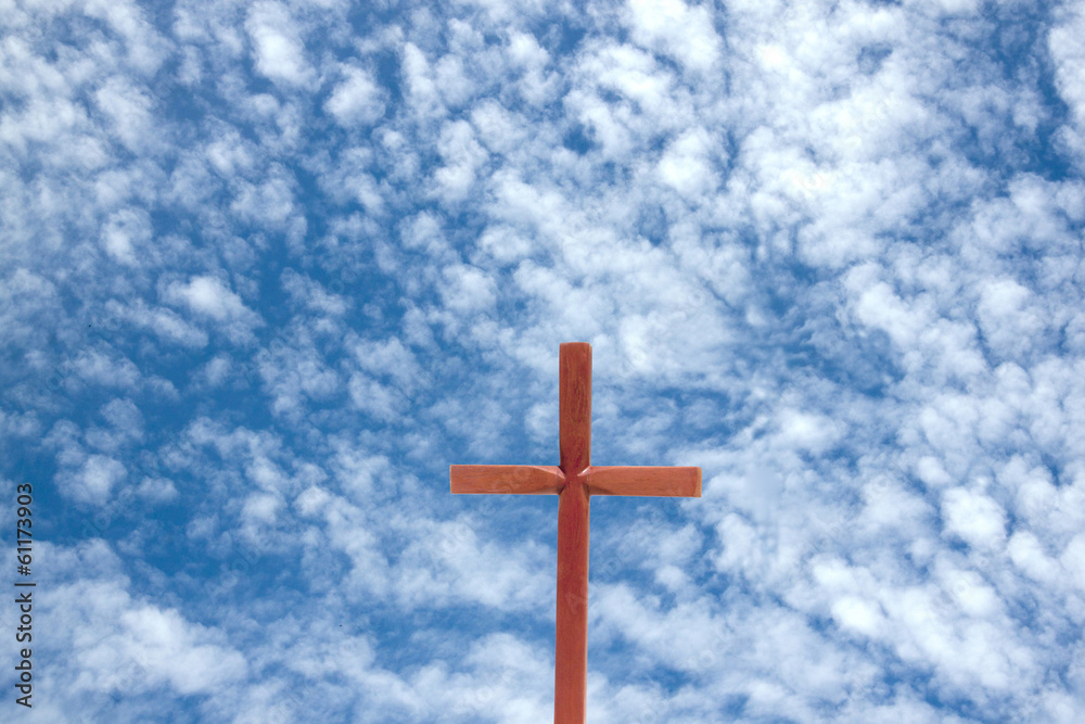 Wooden Cross Against Blue Cloudy Sky Background