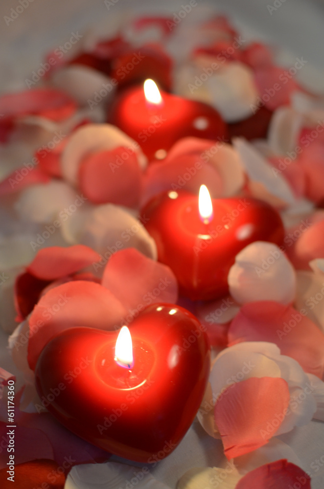 candele rosse accese e petali Stock Photo