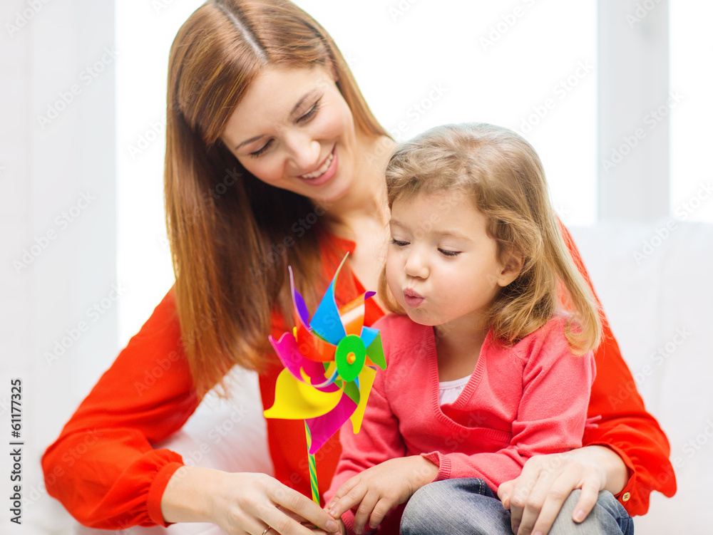 happy mother and daughter with pinwheel toy happy mother and daughter with pinwheel toy