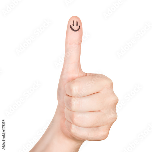 Obraz na plátne Female hand shows thumbs up with smile face on the finger .